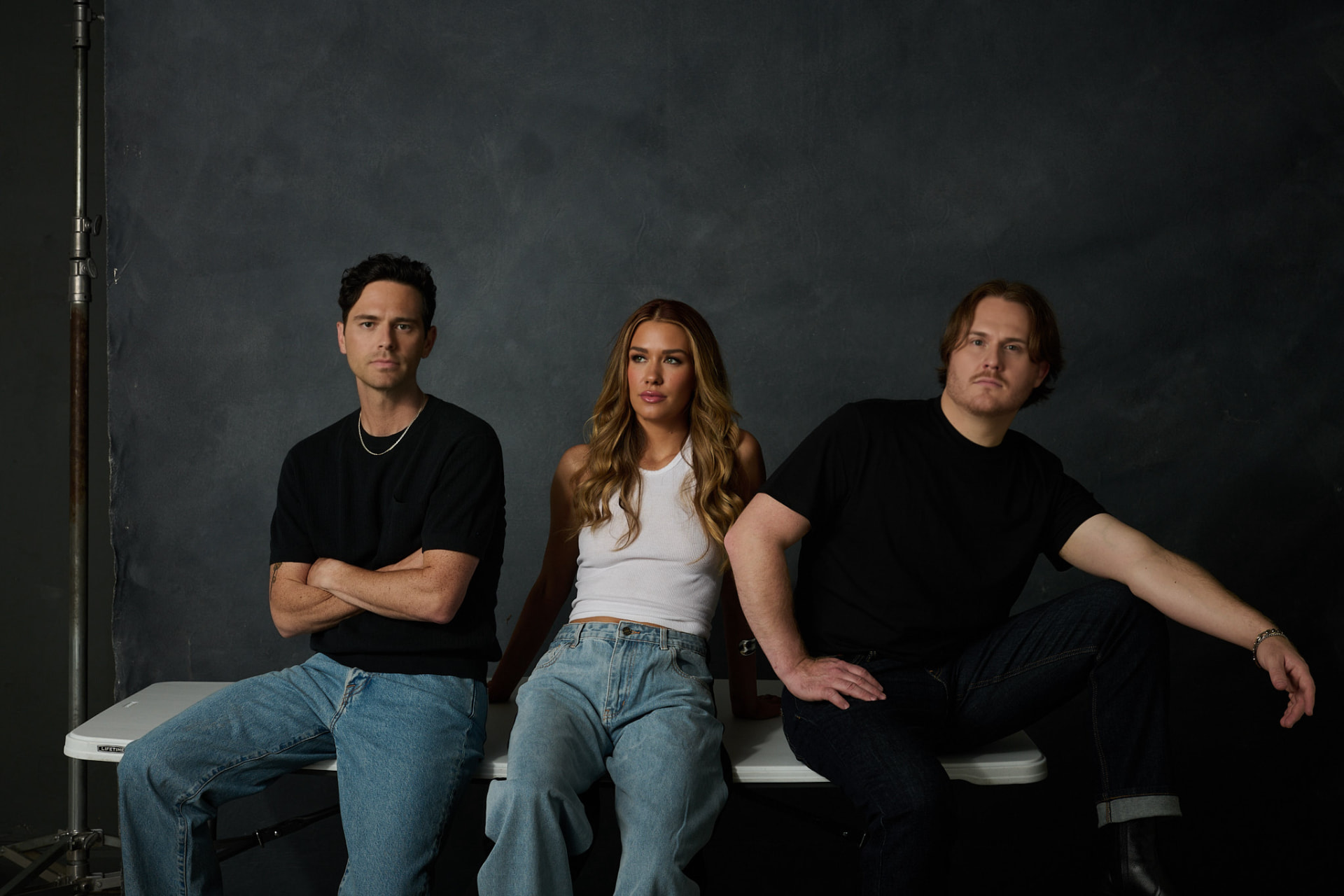 Lost Saints press photo — Afton Addington, Chris Biano and Derrick Casteel seated against a grey studio backdrop